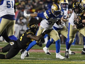 Winnipeg Blue Bombers running back Andrew Harris (33) runs the ball tackled by Hamilton Tiger-Cats defensive back Cariel Brooks (26) in the second half during the 107th Grey Cup championship football game at McMahon Stadium in Calgary on Nov. 24, 2019. Blue Bombers will kick off the 2021 CFL season with a Grey Cup rematch against the Hamilton Tiger-Cats on Thursday, Aug. 5 at IG Field.