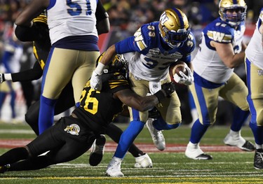 Nov 24, 2019; Calgary, Alberta, CAN; Winnipeg Blue Bombers running back Andrew Harris (33) runs the ball against Hamilton Tiger-Cats defensive back Cariel Brooks (26) in the second half during the 107th Grey Cup championship football game at McMahon Stadium. Mandatory Credit: Eric Bolte-USA TODAY Sports