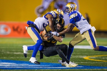 Nov 24, 2019; Calgary, Alberta, CAN; Hamilton Tiger-Cats wide receiver Jaelon Acklin (80) is tackled by Winnipeg Blue Bombers in the second half during the 107th Grey Cup championship football game at McMahon Stadium. Mandatory Credit: Sergei Belski-USA TODAY Sports