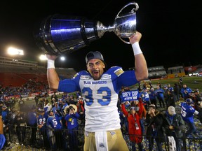 Winnipeg Blue Bombers, Andrew Harris hoists the Grey Cup after beating the  Hamilton Tiger-Cats in the 107th Grey Cup at McMahon stadium in Calgary on Sunday, November 24, 2019.