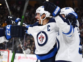 Winnipeg Jets center Mark Scheifele (55) celebrates with captain Blake Wheeler after scoring a goal in the third period against the Vegas Golden Knights to tie the game at T-Mobile Arena in Las Vegas on Saturday.