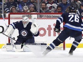 Winnipeg Jets right wing Blake Wheeler (26) watches Winnipeg Jets goaltender Connor Hellebuyck (37) block a shot in the second period against the Vancouver Canucks at Bell MTS Place.