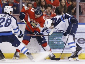 Panthers’ Evgenii Dadonov battles for the puck with Jets Blake Wheeler (right) and Jack Roslovic last night. (Getty Images)