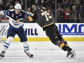 Jets centre Adam Lowry (left) fights Vegas Golden Knights winger Ryan Reaves during the second period on Saturday. Winnipeg players say the fight pumped them up. (David Becker/The Associated Press)