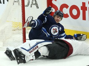 Jets’ Mark Scheifele (left) pleads his innocence after barrelling into Colorado Avalanche goaltender Pavel Francouz during the opening minute of Tuesday night’s game in Winnipeg. Francouz left the game injured. (KEVIN KING/WINNIPEG SUN)