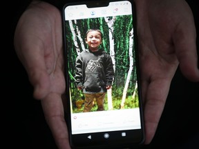 Bianca Smith, aunt of Hunter Straight-Smith, holds a photo of the three-year-old who was allegedly stabbed by his mother's ex-boyfriend on the weekend in Winnipeg as she sits outside the hospital in-between visits to the little boy who remains in a critical condition, Thursday, October 31, 2019. A three-year-old boy who was stabbed multiple times while he slept in his bed will be taken off of life support today.