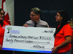 Blair Geisel (centre), CFPD board member and grant committee chair, presents members of Portage’s Bear Clan with $20,000 in funding at a press conference in Portage la Prairie, on Friday, to announce joint funding from the province and Community Foundation of Portage and District to establish a Bear Clan Patrol in Portage.