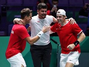Vasek Pospisil and Denis Shapovalov celebrate with Canada team captain Frank Dancevic after defeating Australia in a quarterfinal doubles match at the Davis Cup in Madrid, Spain, on on Thursday, Nov. 21, 2019.