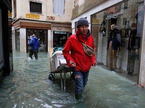 A man walks outside during exceptionally high water levels in Venice, Italy November 13, 2019. (REUTERS/Manuel Silvestri)