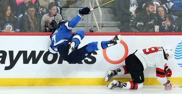 Winnipeg Jets defenceman Dmitry Kulikov (left) is sent flying after a collision with New Jersey Devils forward Taylor Hall in Winnipeg on Tues., Nov. 5, 2019. Kevin King/Winnipeg Sun/Postmedia Network