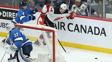 New Jersey Devils forward Miles Wood (right) hustles after the puck with Winnipeg Jets defenceman Neal Pionk in pursuit in Winnipeg on Tues., Nov. 5, 2019. Kevin King/Winnipeg Sun/Postmedia Network