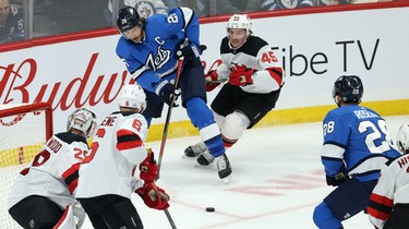 Winnipeg Jets forward Blake Wheeler slides a pass toward Jack Roslovic during action against the New Jersey Devils in Winnipeg on Tues., Nov. 5, 2019. Kevin King/Winnipeg Sun/Postmedia Network