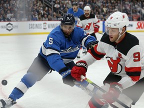 Winnipeg Jets defenceman Luca Sbisa (left) closes on New Jersey Devils forward Taylor Hall in Winnipeg on Tues., Nov. 5, 2019. Kevin King/Winnipeg Sun/Postmedia Network