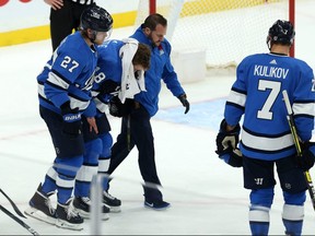 Jets’ Bryan Little is helped off the ice by teammate Nikolaj Ehlers and a member of the team’s medical staff on Nov. 6, 2019 at the Bell MTS Centre.  
Little is now unsure if he'll every play again. Kevin King/Winnipeg Sun