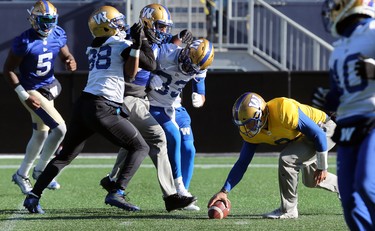 Quarterback Zach Collaros picks up a loose ball as receiver Rasheed Bailey (88) and running back Andrew Harris (33) slow defensive end Jackson Jeffcoat during Winnipeg Blue Bombers practice on Wed., Nov. 6, 2019. Kevin King/Winnipeg Sun/Postmedia Network