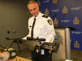 Insp. Max Waddell of the Winnipeg Police Service shows off an Accuracy International .50 calibre rifle capable of hitting targets up to two miles away, part of an arsenal of 22 firearms including four .50 calibre desert eagle semi-automatic handguns on Tuesday. The weapons were seized at a home on Marine Drive in south St. Vital on Friday.