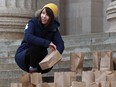 Emily Leedham of Fight for 15 helps fill brown paper bags that illustrate the missed lunches of children living in poverty during a rally organized by the Social Planning Council of Winnipeg to call attention to the anniversary of the failure of the federal government to end child poverty by 2000 on the steps of the Manitoba Legislative Building in Winnipeg on Monday.
