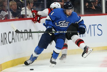 Winnipeg Jets defenceman Neal Pionk (right) absorbs a hit from New Jersey Devils centre Jesper Boqvist in Winnipeg on Tues., Nov. 5, 2019. Kevin King/Winnipeg Sun/Postmedia Network