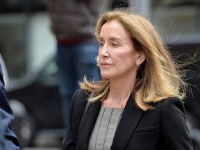 Actress Felicity Huffman is escorted by police into court where she pleaded guilty to one count of conspiracy to commit mail fraud and honest services mail fraud before Judge Talwani at John Joseph Moakley United States Courthouse in Boston, Massachusetts, May 13, 2019. (Joseph Prezioso / AFP)J