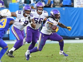 Running back Mike Boone #23 of the Minnesota Vikings runs for a first down in the second half of the game against the Los Angeles Chargers at Dignity Health Sports Park on December 15, 2019 in Carson, California.