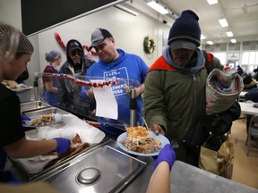 A man is served a pizza and turkey sandwich lunch at the Lighthouse Mission on Main Street in Winnipeg on Wed., Dec. 25, 2019. Kevin King/Winnipeg Sun/Postmedia Network