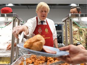 Britain's Prime Minister Boris Johnson serves Christmas lunch to British troops stationed in Estonia. He's a 2019 winner –– who could soon become a loser.