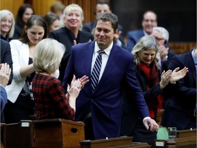 Conservative leader Andrew Scheer is applauded by MP Michelle Rempel (L) and other members of his party after his speech announcing that he is stepping down as party leader.