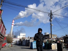 A man walks near a coal-fired power plant in Harbin, Heilongjiang province, China Nov. 27, 2019.