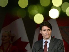 Christmas lights on a wreath glow above Prime Minister Justin Trudeau as he speaks to supporters at the Laurier Club Holiday Reception, an annual donor event held by the Liberal Party of Canada, in Ottawa, Dec. 9, 2019. (THE CANADIAN PRESS/Justin Tang)