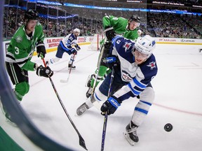 Dallas Stars defenseman John Klingberg (3) and Winnipeg Jets center Andrew Copp (9) chase the puck during the third period at the American Airlines Center on Thursday.