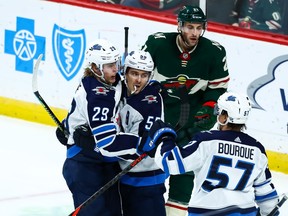 Winnipeg Jets right wing Patrik Laine (29) celebrates with center Mark Scheifele (55) and left wing Gabriel Bourque (57) after scoring a goal against the Minnesota Wild in the second period at Xcel Energy Center.