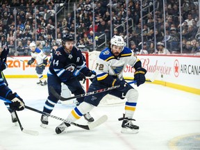 Dec 27, 2019; Winnipeg, Manitoba, CAN;  St. Louis Blues defenseman Justin Faulk (72) battles for the puck with Winnipeg Jets defenseman Josh Morrissey (44) during the first period at Bell MTS Place. Mandatory Credit: Terrence Lee-USA TODAY Sports