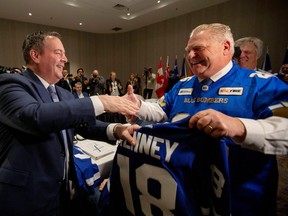 Ontario Premier Doug Ford presents a hockey jersey to Alberta Premier Jason Kenney as Canada's provincial premiers meet in Toronto, Ontario, Canada December 2, 2019. REUTERS/Carlos Osorio