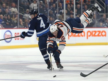 Winnipeg Jets defenceman Neal Pionk (left) upends Edmonton Oilers forward Joakim Nygard with a hip check during NHL pre-season action at Bell MTS Place in Winnipeg on Thurs., Sept. 26, 2019. Kevin King/Winnipeg Sun/Postmedia Network ORG XMIT: POS1909262010120567