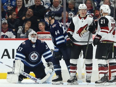 Winnipeg Jets goaltender Connor Hellebuyck (left) looks up at Josh Morrissey after a clearing attempt went into the Jets net during NHL action against the Phoenix Coyotes in Winnipeg on Tues., Oct. 15, 2019. Christian Dvorak (18) was credited with the goal. Kevin King/Winnipeg Sun/Postmedia Network ORG XMIT: POS1910152100598143