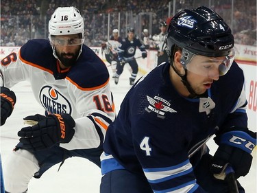 Winnipeg Jets defenceman Neal Pionk (right) is lined up by Edmonton Oilers forward Jujhar Khaira during NHL action in Winnipeg on Sun., Oct. 20, 2019. Kevin King/Winnipeg Sun/Postmedia Network ORG XMIT: POS1910202136198663