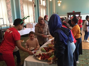 Families fill their plates as the Newcomers Employment and Education Development Services (N.E.E.D.S.) Inc. hosted their ninth Annual Winter Holiday Celebration for newcomer children, youth and families on Saturday at the Marlborough Hotel.