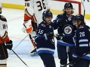 Mark Scheifele, Kyle Connor and Blake Wheeler (from left) of the Winnipeg Jets celebrate the game-winning goal from Scheifele against the Anaheim Ducks in Winnipeg on Sunday.