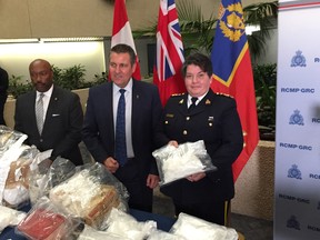 RCMP Assistant Commissioner Jane MacLatchy holds a bag containing methamphetamine with Winnipeg Deputy Mayor Markus Chambers (left) and Manitoba Justice Minister Cliff Cullen (centre) at a press conference on Tuesday, at RCMP D Division headquarters in Winnipeg to announce the conclusion of Project Declass, a 16-month investigation into a drug network operating out of Winnipeg.