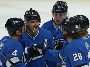 Winnipeg Jets centre Mark Scheifele (second from left) acknowledges a pass from Blake Wheeler (second from right) after scoring against the Philadelphia Flyers in Winnipeg on Sun., Dec. 15, 2019. Neal Pionk, Patrik Laine and Kyle Connor (from left) join in. Kevin King/Winnipeg Sun/Postmedia Network
