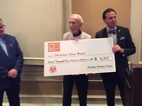 Sudhir Sandhu, Chief Executive Officer of the Manitoba Building Trades (right), presents Christmas Cheer Board executive director Kai Madsen with a cheque for $12,500 on Wednesday, Dec. 18, 2019, at the Manitoba Club in Winnipeg. Peter Wightman, executive director of Construction Labour Relations Association of Manitoba, stands to left of Madsen.
