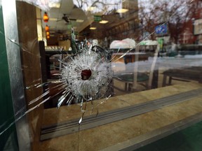 A bullet hole in the window of a Subway restaurant on River Avenue at Osborne Street in Winnipeg on Sunday. Police say a 20-year-old man is in hospital in stable condition after being shot early Sunday morning.