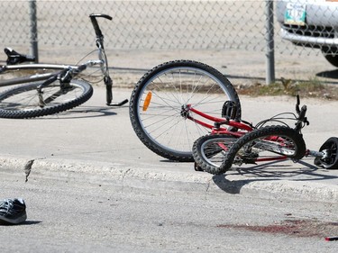 A bicycle with a bent back rim, a blood stain and a running shoe lie near the scene of a fatal motor vehicle collision involving a cyclist near the intersection of Higgins Avenue and King Street in Winnipeg on Tues., June 4, 2019.  Kevin King/Winnipeg Sun/Postmedia Network ORG XMIT: POS1906041713271170