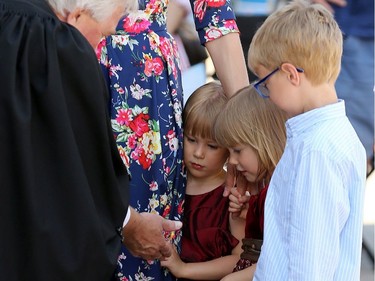Twins Amelia and Alyssa Koval, 3, meet former chief of protocol Dwight MacAulay, who presided over a special citizenship ceremony at Assiniboine Park in Winnipeg on Mon., July 1, 2019. Kevin King/Winnipeg Sun/Postmedia Network ORG XMIT: POS1907011511140054