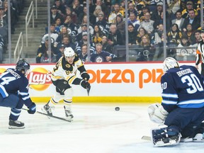 Boston Bruins forward David Pastrnak takes a shot against Winnipeg Jets goalie Laurent Brossoit during Friday's game. (USA TODAY SPORTS)