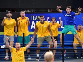 Team Australia players Nick Kyrgios and Alex de Minaur are seen celebrating as their team mates Chris Guccione and John Peers play their doubles match against Felix Auger-Aliassime and Adil Shamasdin of Canada during the ATP Cup tennis tournament at Pat Rafter Arena in Brisbane, Australia, January 5, 2020. (AAP Image/Darren England/via REUTERS)