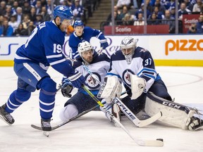 Maple Leafs centre Jason Spezza (19) shoots on Jets goaltender Connor Hellebuyck as defenceman Tucker Poolman closes in during seoncd-period action in Toronto on Wednesday January 8, 2020. (FRANK GUNN/THE CANADIAN PRESS)