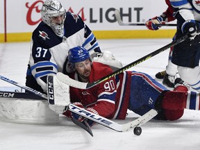 Winnipeg Jets goalie Connor Hellebuyck (37) stops the puck and Montreal Canadiens forward Tomas Tatar (90) during the second period at the Bell Centre. Eric Bolte-USA TODAY Sports ORG