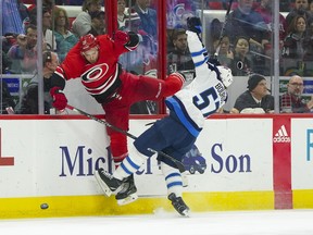 Jets forward Gabriel Bourque (right) collides with the Hurricanes' Nino Niederreiter during the third period at PNC Arena in Raleigh, N.C., last night.  USA TODAY Sports