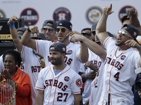 Houston Astros George Springer, right, Carlos Correa, centre, reacts as fans cheer for Jose Altuve, bottom centre, during the Astros victory parade on Nov. 3, 2017 in Houston, Texas. (Tim Warner/Getty Images)